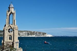 Wellington Clock Tower, Swanage. Deep blue sea, blue sky, cliffs in the background