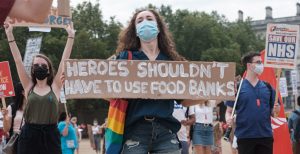 Medic holds up sign saying heroes shouldn't have to use foodbanks