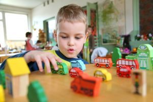 child playing with wooden toys in early years class