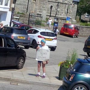 woman standing in St Just square with a Black lives Matter placard