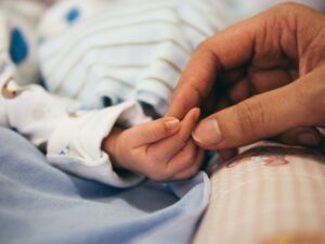 Mother holding sick child's hand