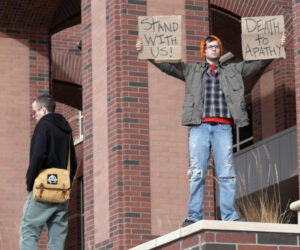 protestor holds up placard urging people to take action